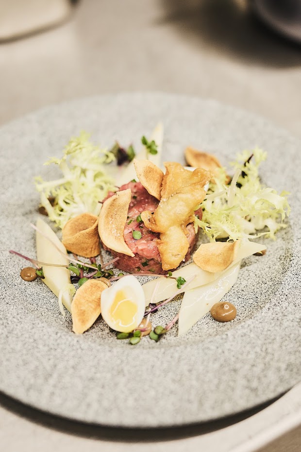 Aufwendig angerichtetes Rindfleisch-Tatar mit Zutaten – Handwerkskunst auf dem Teller