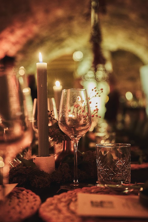 Stimmungsvolles Kerzenlicht und Weinglas im Gewölbekeller – romantische Silvesterstimmung