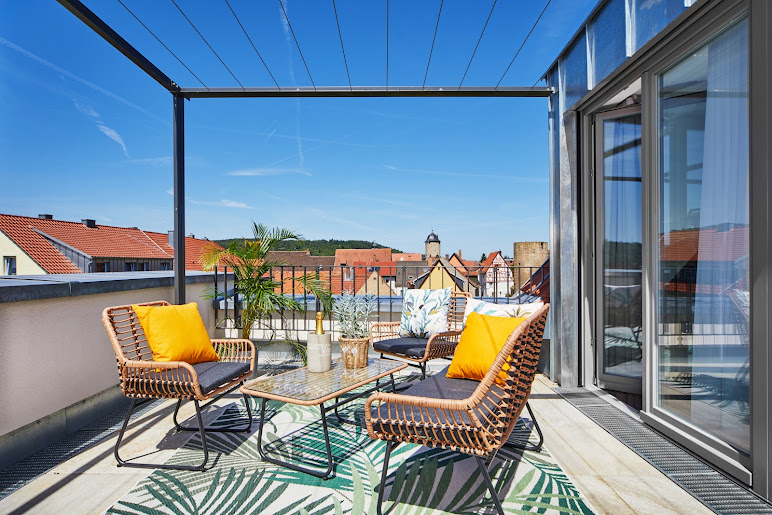 Sonnige Dachterrasse mit Pergola und Korbsesseln in der Ferienwohnung Weinforum Franken mit Blick über Eibelstadt