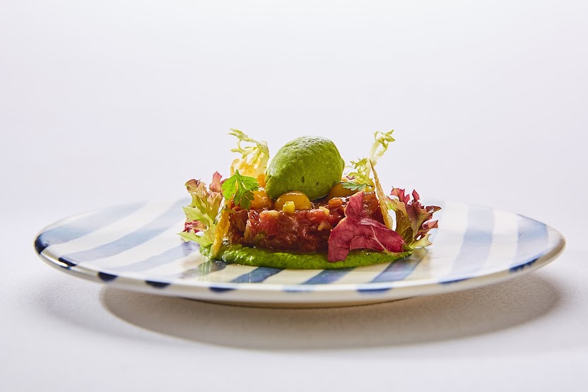 Handgeschnittenes Tatar mit Avocado-Mousse auf blau-weißem Manufaktur-Geschirr – Handwerksküche Weinforum Franken