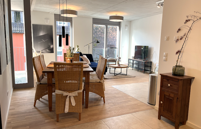 Gemütlicher Wohnbereich mit Holzesstisch und Holzboden in der Ferienwohnung Weinforum Franken