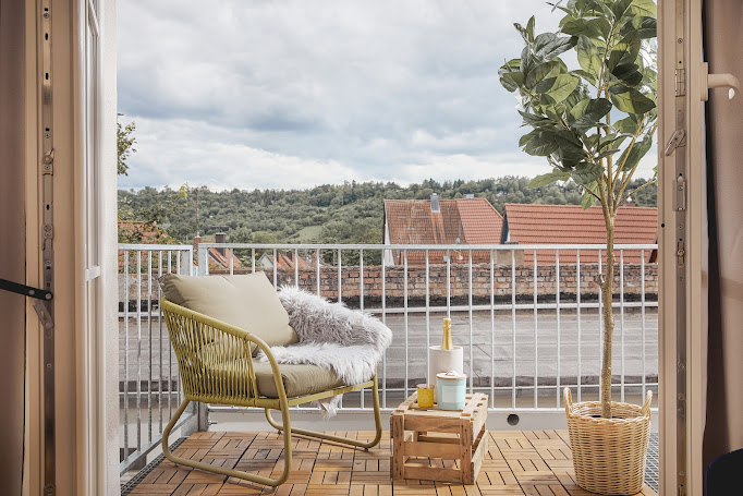 Privater Balkon mit Sessel und Blick über die Dächer